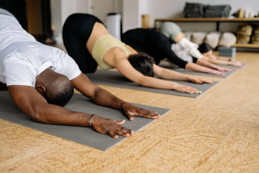 Person dehnt sich auf einer Yogamatte